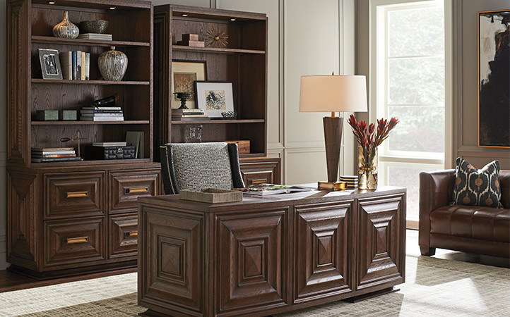 Dark brown desk with chair and two matching brown bookcases with file cabinets.