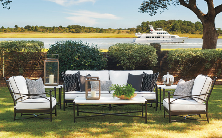 Outdoor Setting with white and black sofa and chairs.  Boat in the Background