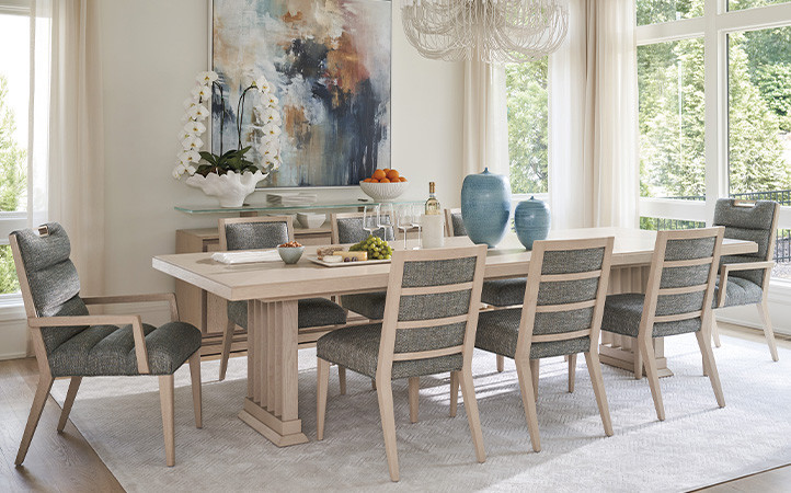 Sunset Key dining room scene featuring long dining table with side and arm chairs.